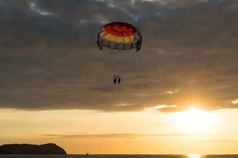 Parasailing at sunset over the sea
