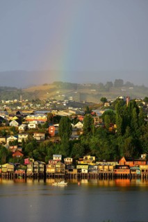 Rainbow over the city with stilt houses