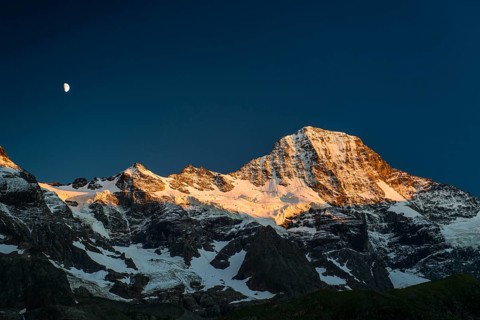 Snow-capped Breithorn with moon at sunset