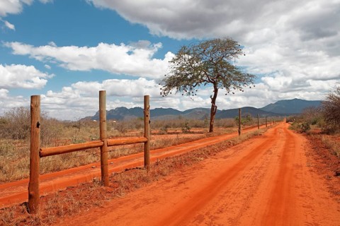 Electric fence of Rhino Sanctuary on red dirt road