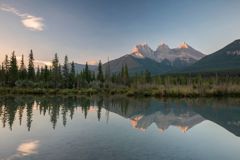 Three Sisters reflecting in calm water
