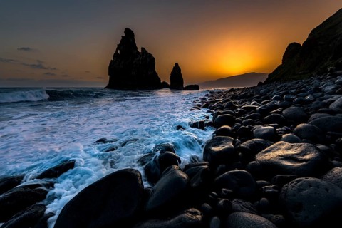Rock formation Ribeira de Janela at sunrise with black stones at the beach