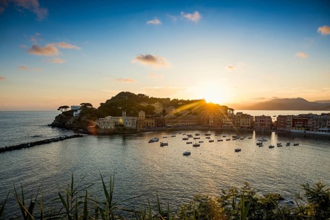 View of the village with harbour in the bay Baia del Silenzio at sunset