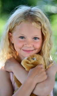 Little girl with blonde hair and cuddly toy