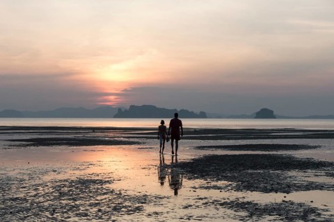 Couple at low tide on the beach at sunset