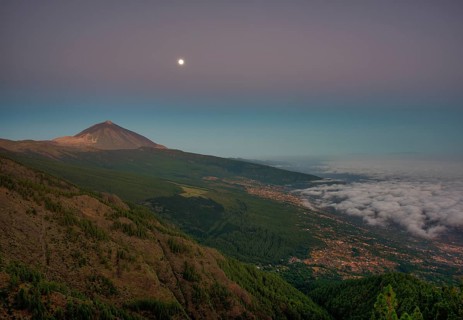 Night view of trade wind clouds over Orotava valley with Pico del Teide in front of sunrise