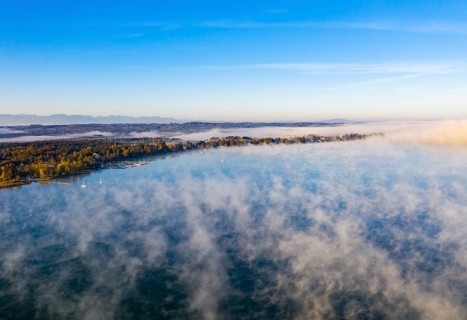Morning fog over Lake Starnberg with view on Seeshaupt near Munsing