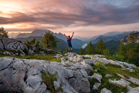 Hiker stretches his arms into the air
