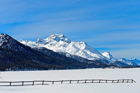 Summit Piz de la Margna above the frozen Lake Silvaplana