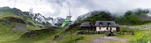 Landawirseehutte and Alpine Club flag with cloudy Alpine valley