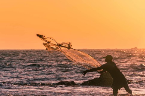 Local fisherman casts fishing net