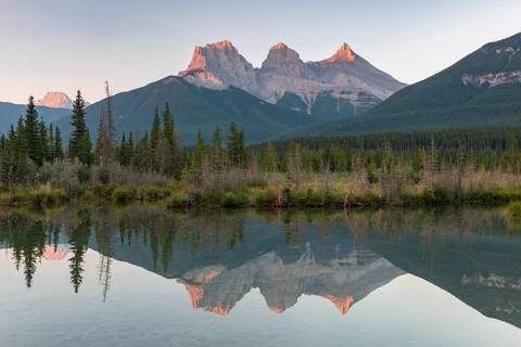 Three Sisters reflecting in calm water