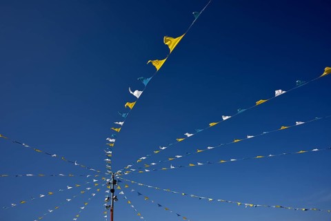 Colorful pennant against a blue sky at a festival