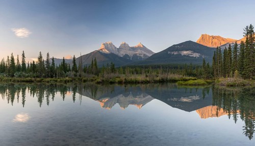 Three Sisters reflecting in calm water