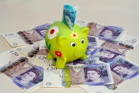 Piggy bank on twenty pound British banknotes