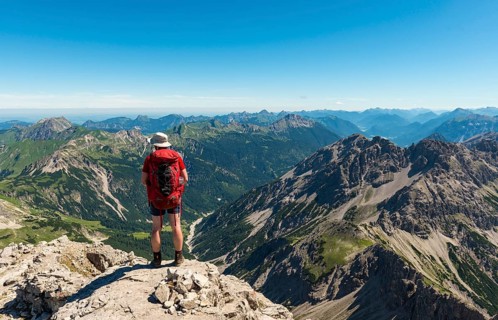 Hikers look out over mountains and alps