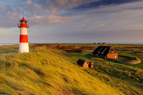 Lighthouse List-Ost with typical Frisian houses with thatched roof
