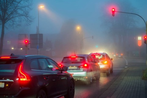 Cars at a red light in fog at night