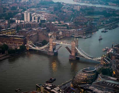 View of opened and illuminated Tower Bridge across the River Thames