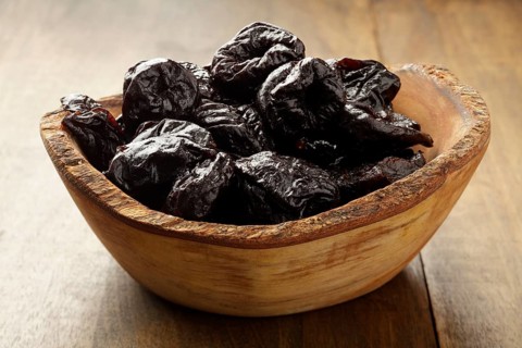 Dried Prunes in wooden bowl
