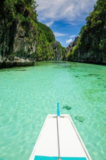 Front of an outrigger boat in the crystal clear water in the Bacuit archipelago