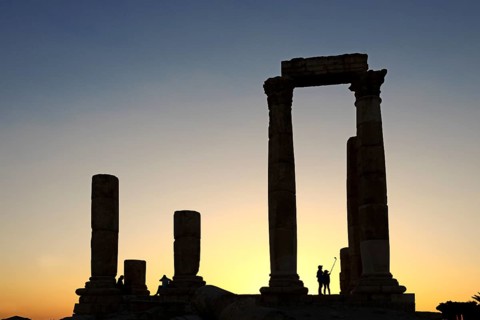 Couple takes pictures with a selfie-stick in sunset at the Temple of Hercules at the Citadel