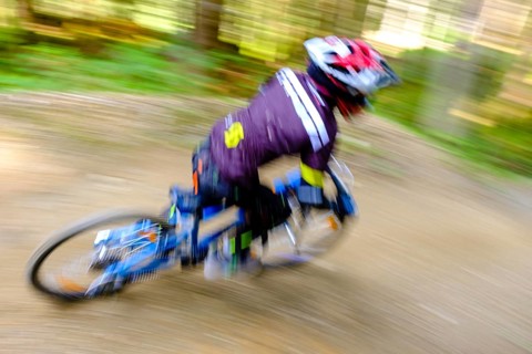 Child 9 years old rides on a mountain bike downhill