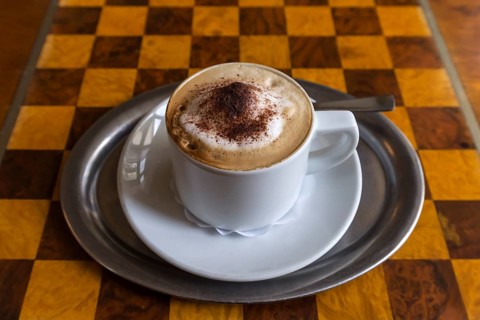 Cappuccino on table with chessboard pattern