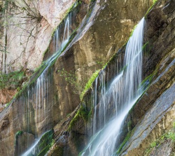 Waterfall on mossy slope in gorge