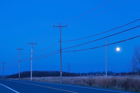 Highway bordered by hydro electricity distribution poles