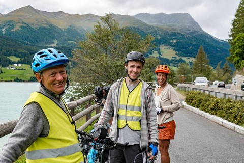 Three cyclists with mountain bikes and safety vest