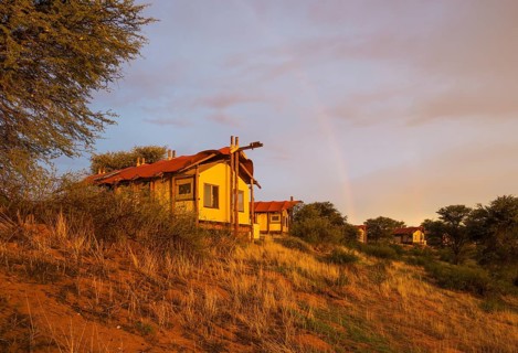 Stilt canvas tents of the Kalahari Tented Camp at ridge of sand dune