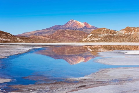 Volcano Cerro Tunupa with reflection in the Salar de Uyuni