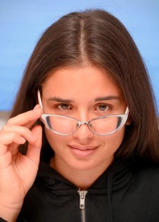Young dark-haired woman looking over her eye glasses