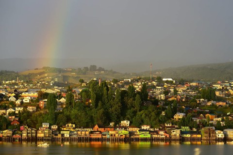 Rainbow over the city with stilt houses