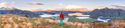 Hiker overlooking Lake Wanaka and mountains