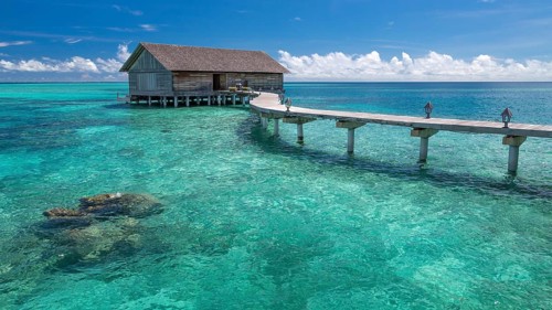 Wooden hut on stilts in lagoon