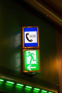 Illuminated emergency exit and SOS signs in a road tunnel
