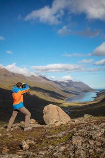 Photographer photographs view from Mjoafjaroarheioi Pass onto Mjoifjorour Fjord
