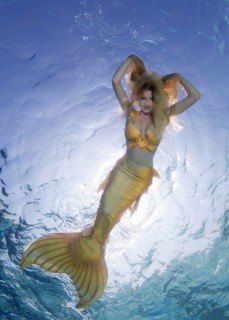 Golden-haired mermaid swims under the water