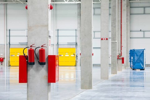 Modern empty storehouse with fire extinguishers
