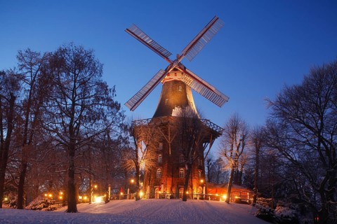 Illuminated Herdentorswallmuhle wind mill in the ramparts with snow