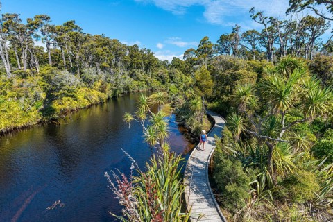 Female hiker at river with path