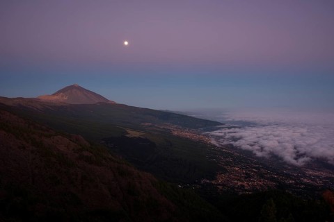 Night view of trade wind clouds over Orotava valley with Pico del Teide in front of sunrise