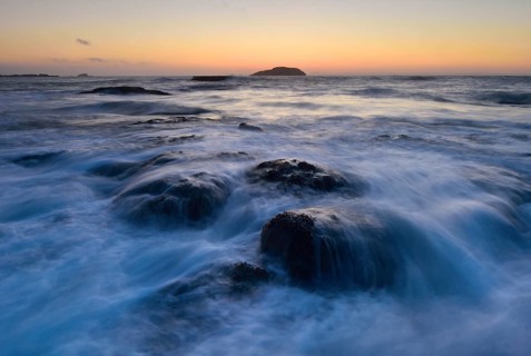 Waves washing around rocks in the ocean