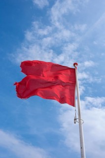 Waving red flag on the beach