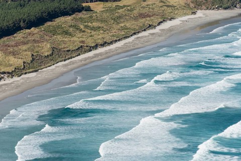 Spinning waves breaking at the flat sand beach
