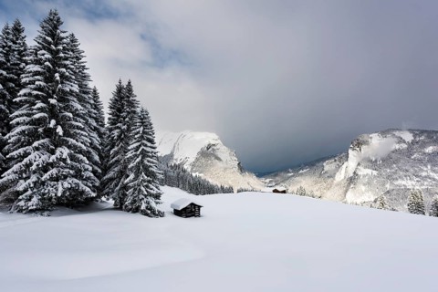 Small country cottage in snowy mountain landscape