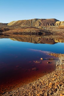 Mineral-rich ground and rocks with rainwater pool at Rio Tinto mines
