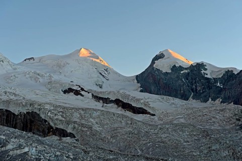 First rays of sunshine at the Castor and Pollux peaks above the border glacier